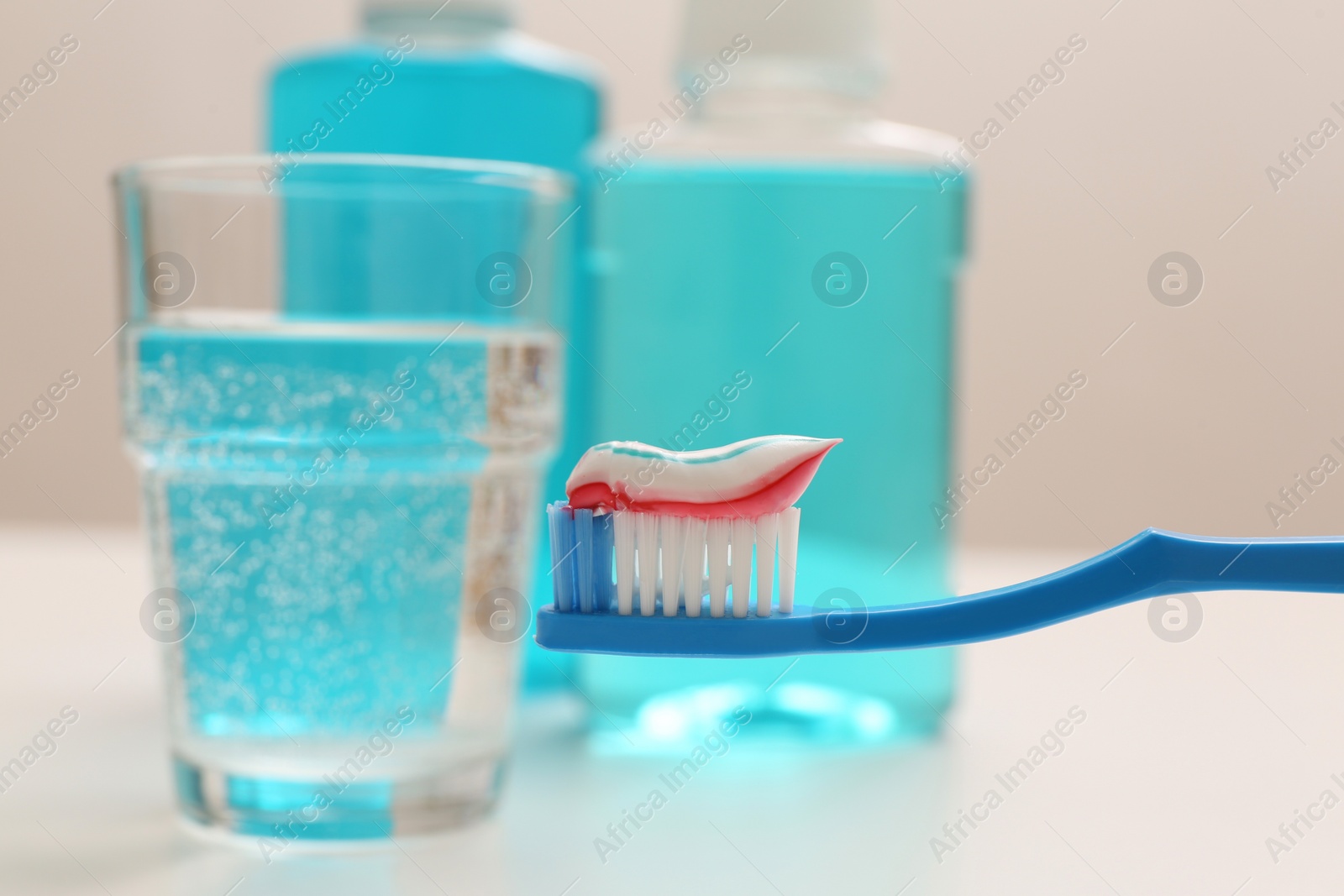 Photo of Brush with toothpaste on blurred background, closeup