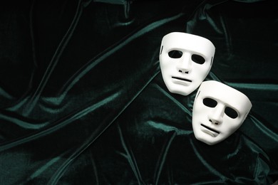 Photo of Theater arts. White masks on green fabric, top view. Space for text