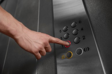 Man choosing floor in elevator, closeup view