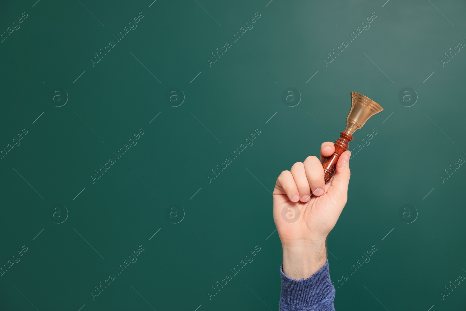 Photo of Teacher with school bell near chalkboard, closeup. Space for text