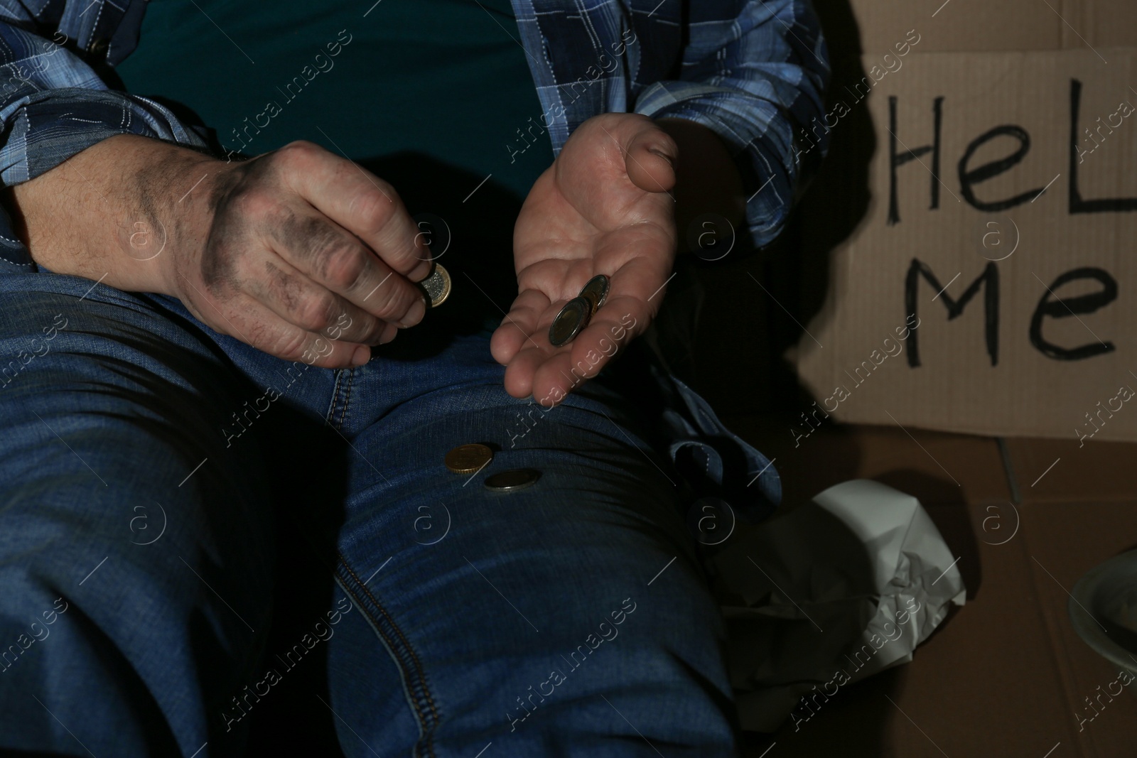 Photo of Poor senior man counting coins near cardboard sign HELP ME, closeup