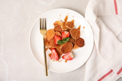 Photo of Cereal pancakes with strawberries on light grey marble table, flat lay