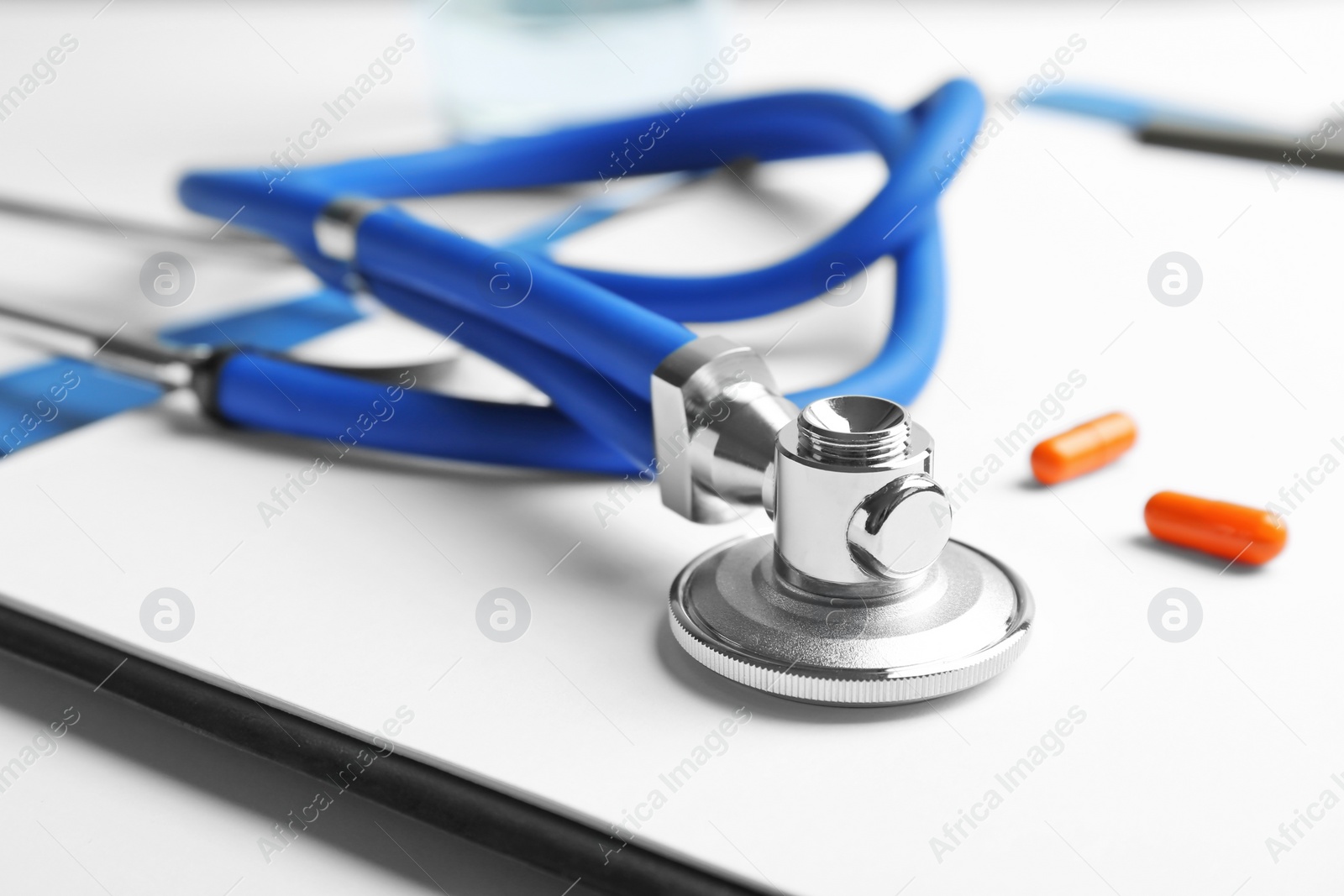 Photo of Stethoscope, clipboard and pills, closeup. Medical equipment