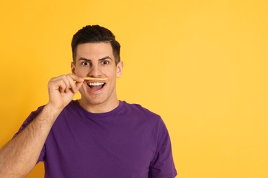 Man with French fries on orange background, space for text
