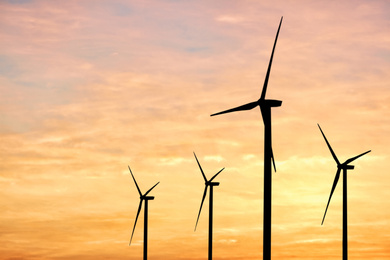 Image of Silhouettes of wind turbines at sunset. Alternative energy source