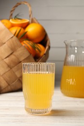 Photo of Tasty freshly made orange juice on white wooden table