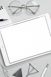 Photo of Flat lay composition with modern tablet on light grey background. Space for text