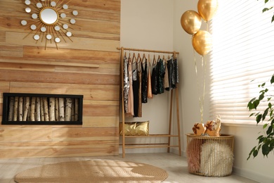 Rack with stylish women's clothes in room. Interior design