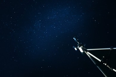 Photo of Modern telescope and beautiful sky with stars in night outdoors, low angle view. Learning astronomy