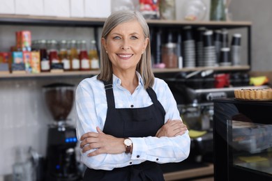 Photo of Portrait of happy business owner in her coffee shop