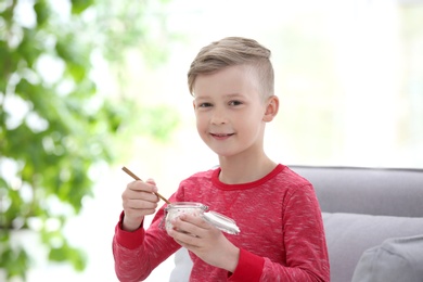 Little boy with yogurt indoors