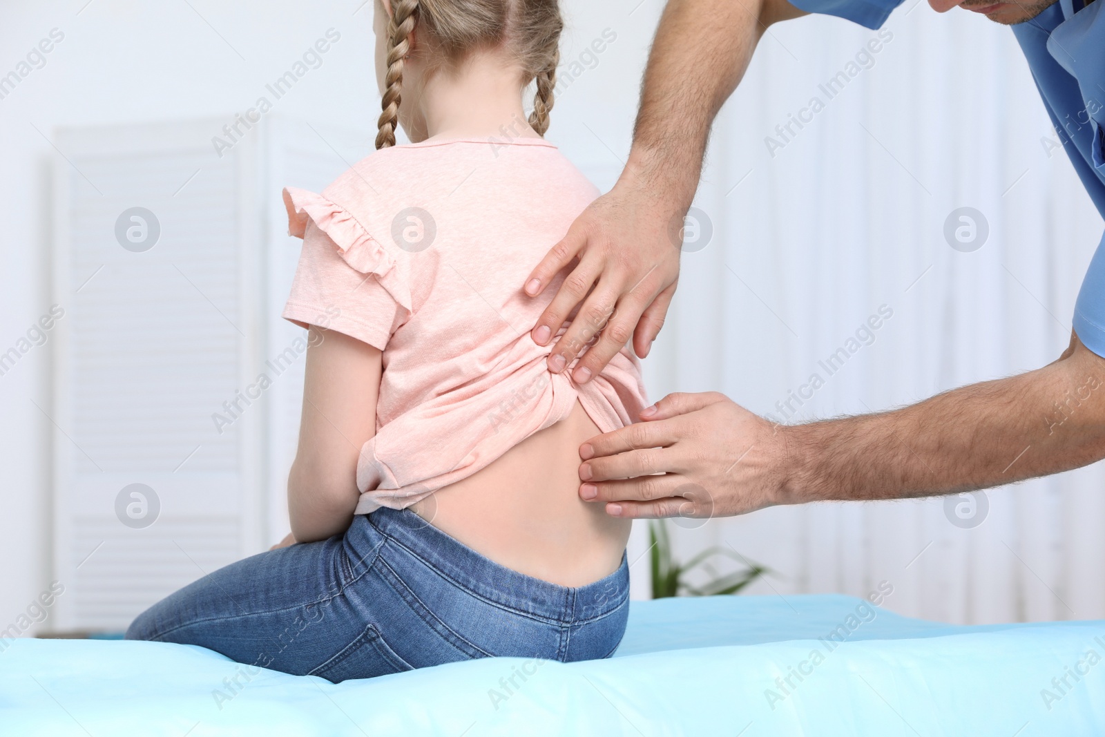 Photo of Orthopedist examining child's back in clinic, closeup. Scoliosis treatment