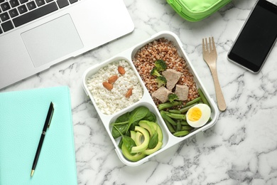 Photo of Flat lay composition with container of natural protein food on office table