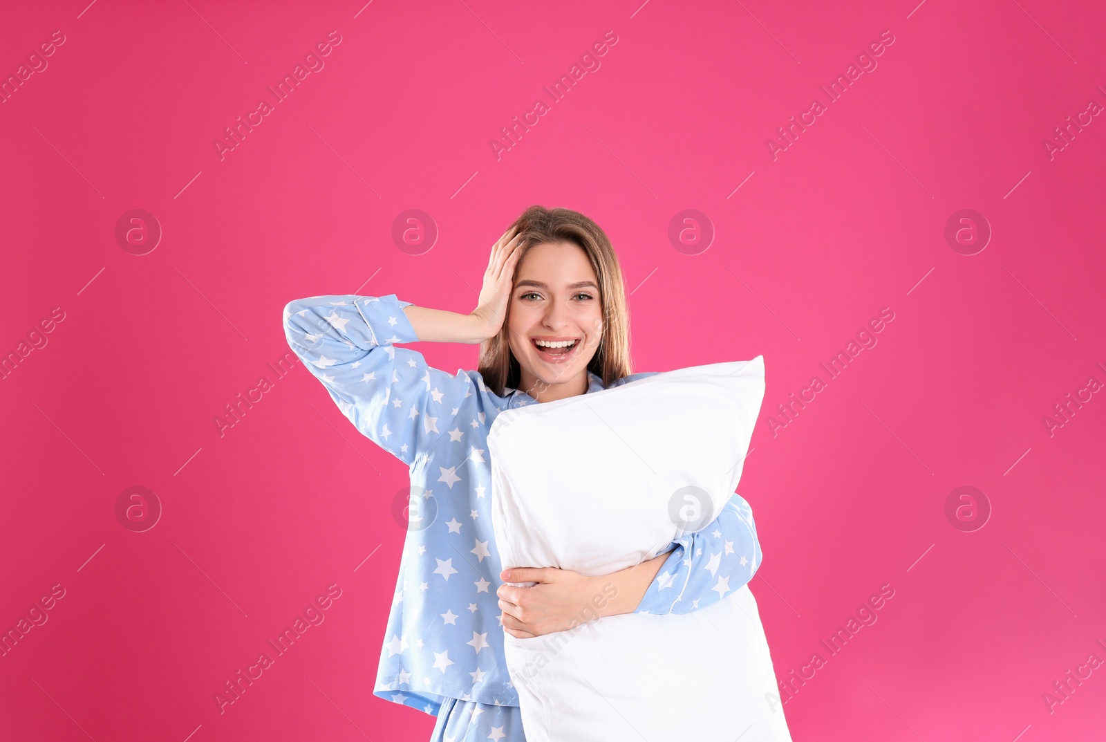 Photo of Young woman with pillow on pink background