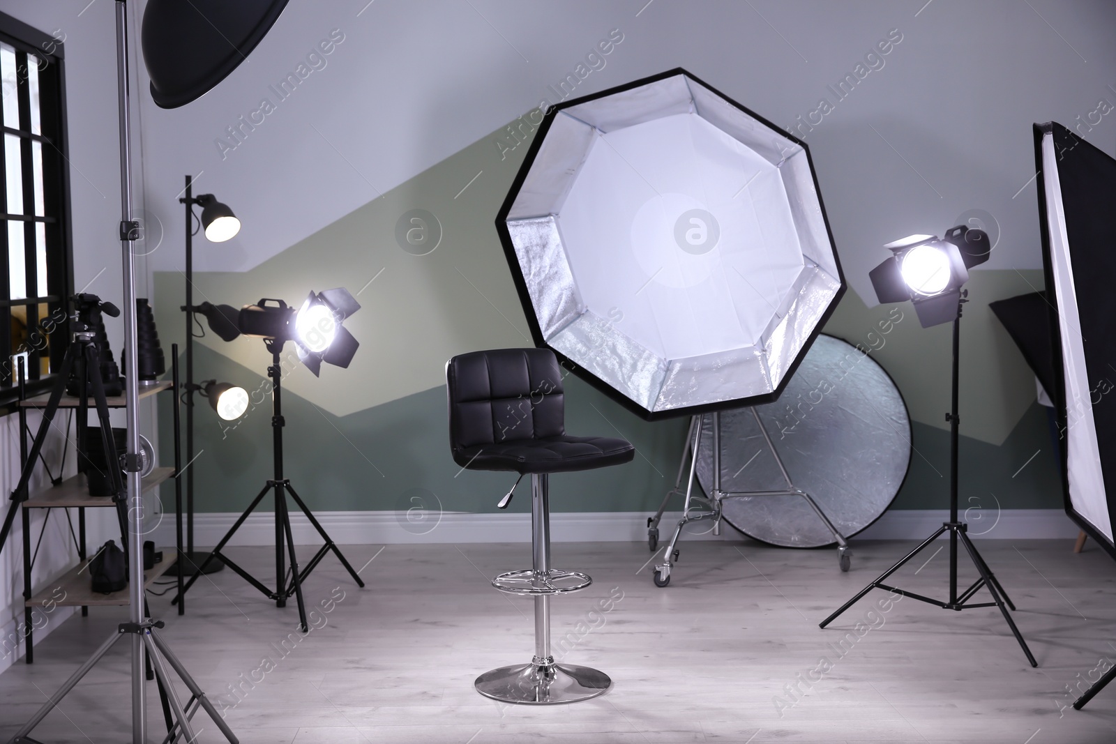 Photo of Interior of modern photo studio with bar stool and professional equipment