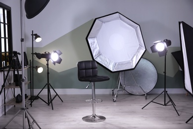 Interior of modern photo studio with bar stool and professional equipment