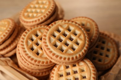 Tasty sandwich cookies with cream in wooden tray, closeup