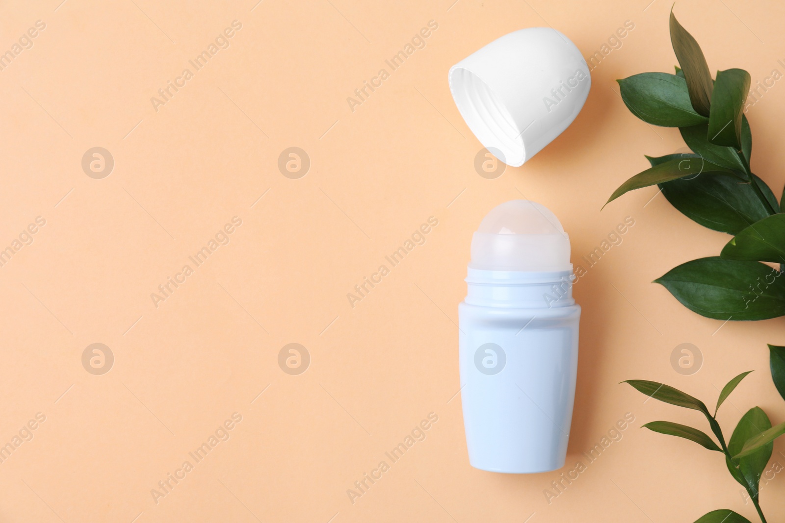 Photo of Flat lay composition with natural roll-on deodorant on beige background, space for text