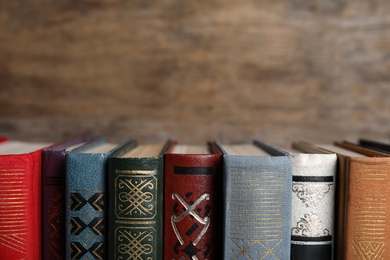 Photo of Stack of hardcover books on wooden background, closeup. Space for text