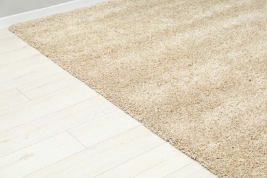 Photo of Soft beige carpet on white laminated floor indoors