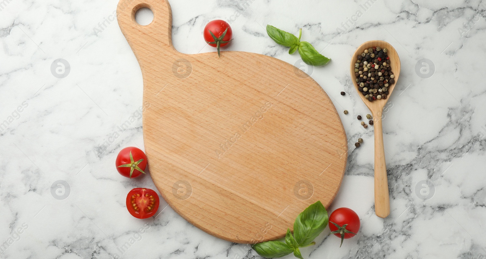 Photo of Cutting board, basil, spices and tomatoes on white marble table, flat lay. Space for text