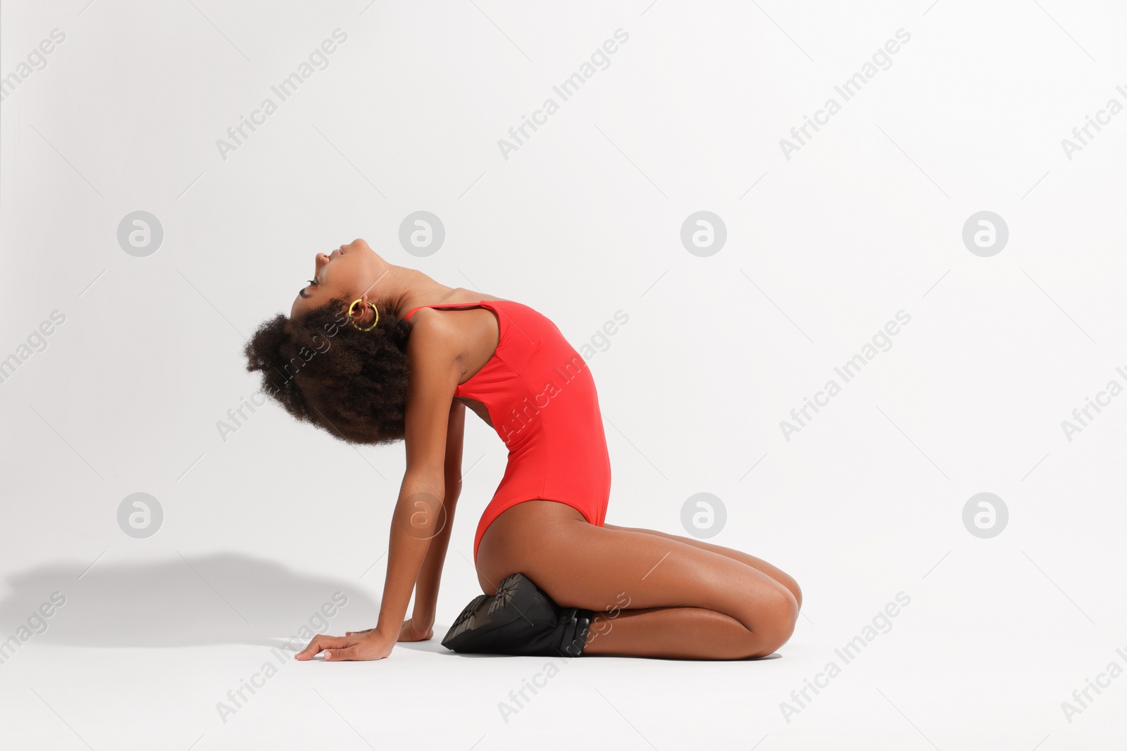 Photo of Beautiful woman in red one-piece summer swimsuit posing on white background