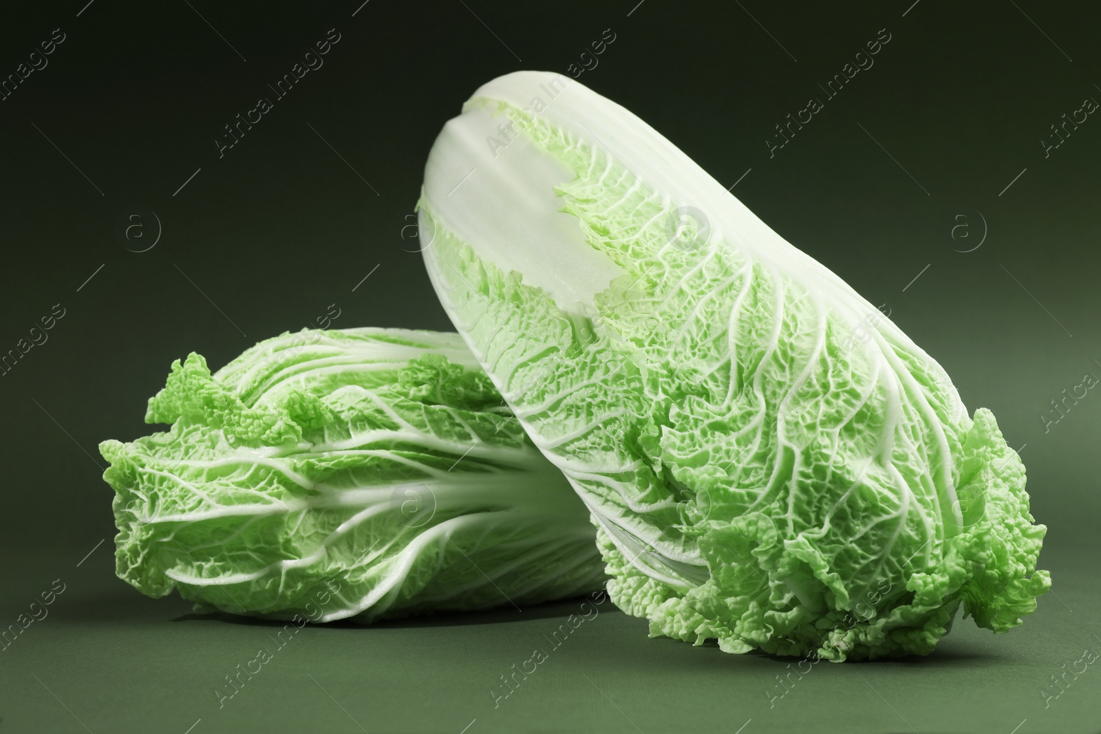 Photo of Fresh ripe Chinese cabbages on green background, closeup