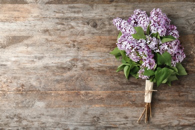 Photo of Blossoming lilac on wooden background, top view. Spring flowers