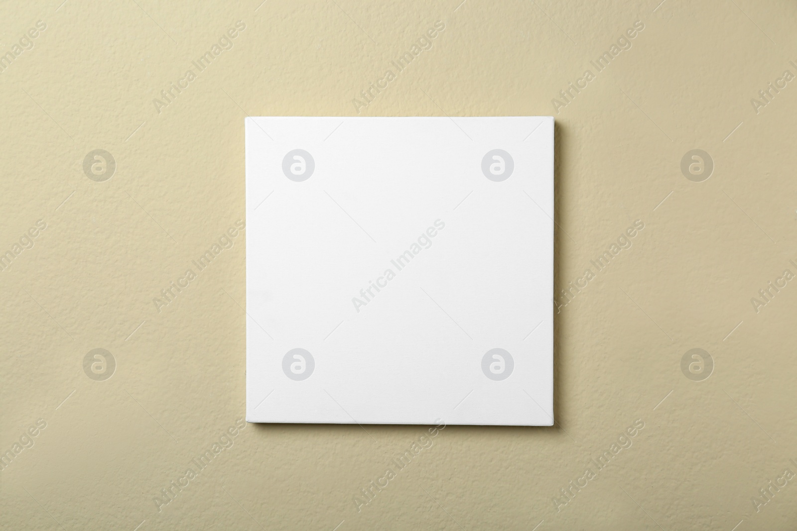 Photo of Blank canvas on beige wall. Space for design