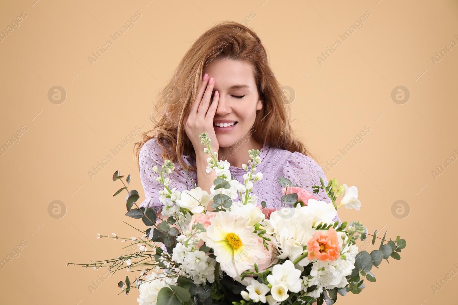 Photo of Beautiful woman with bouquet of flowers on beige background