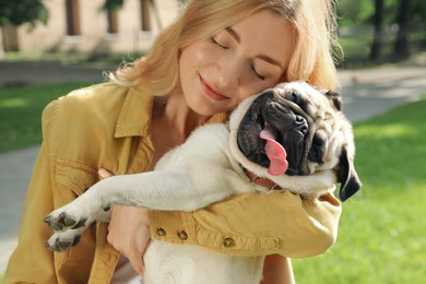 Photo of Woman with cute pug dog outdoors on sunny day. Animal adoption