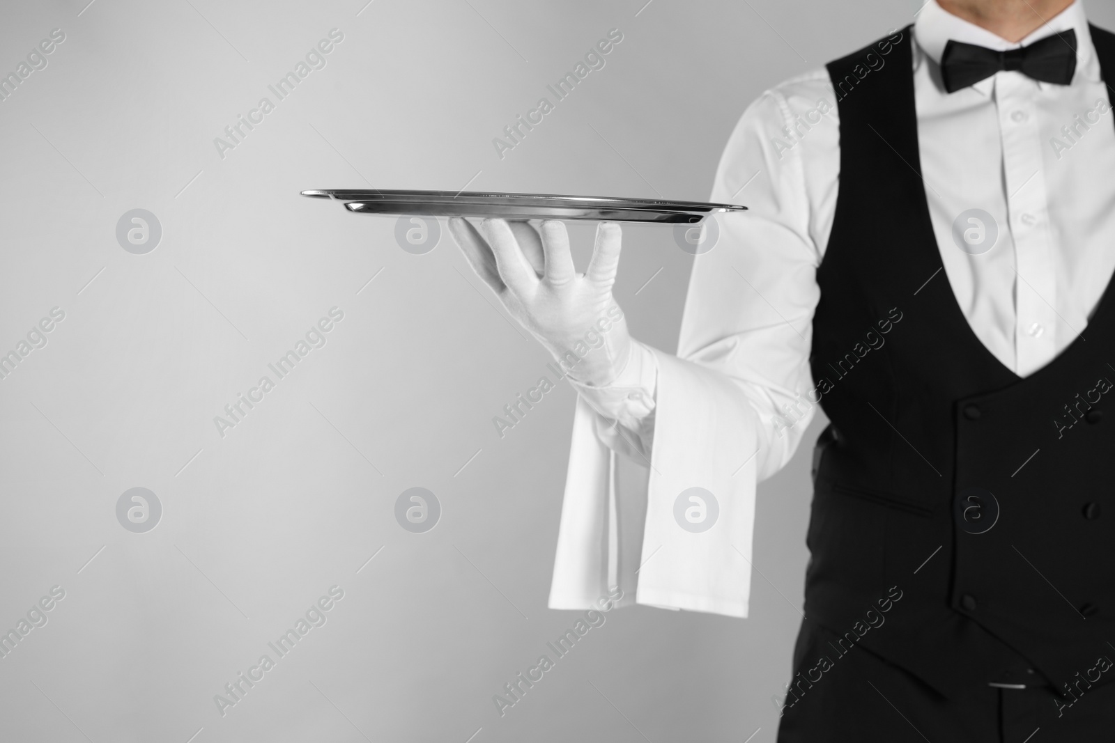 Photo of Butler with tray on light grey background, closeup. Space for text