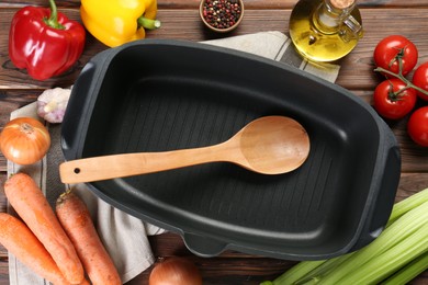 Photo of Black pot with different products and spoon on wooden table, flat lay