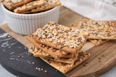 Cereal crackers with flax, sunflower and sesame seeds on table, closeup