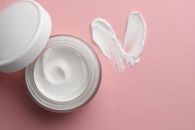 Jar of face cream and samples on pink background, top view