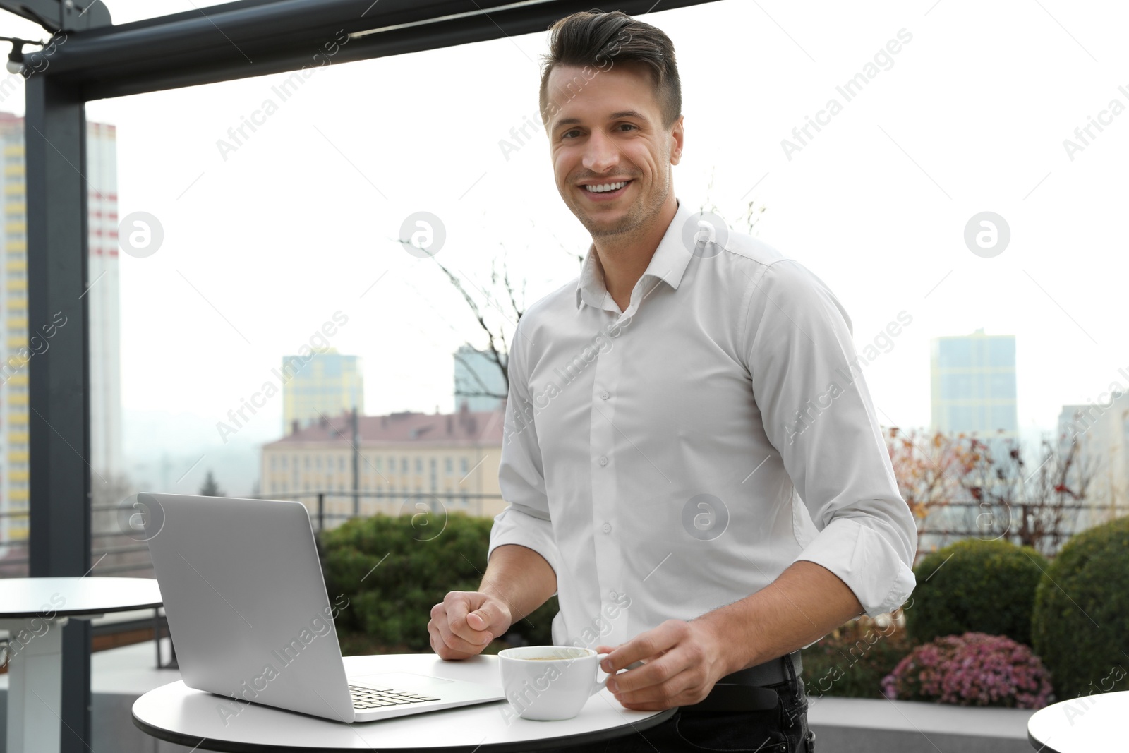 Photo of Businessman working with laptop in outdoor cafe. Corporate blog