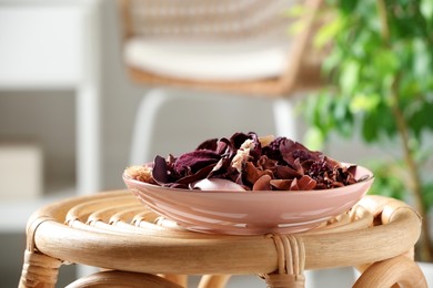 Aromatic potpourri of dried flowers in bowl on wicker table indoors