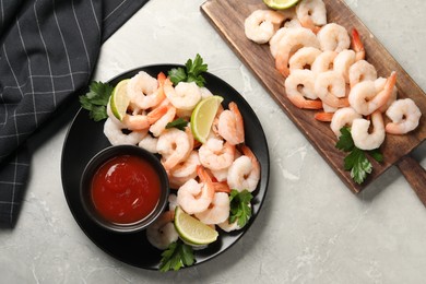 Photo of Tasty boiled shrimps with cocktail sauce, parsley and lime on light grey table, flat lay