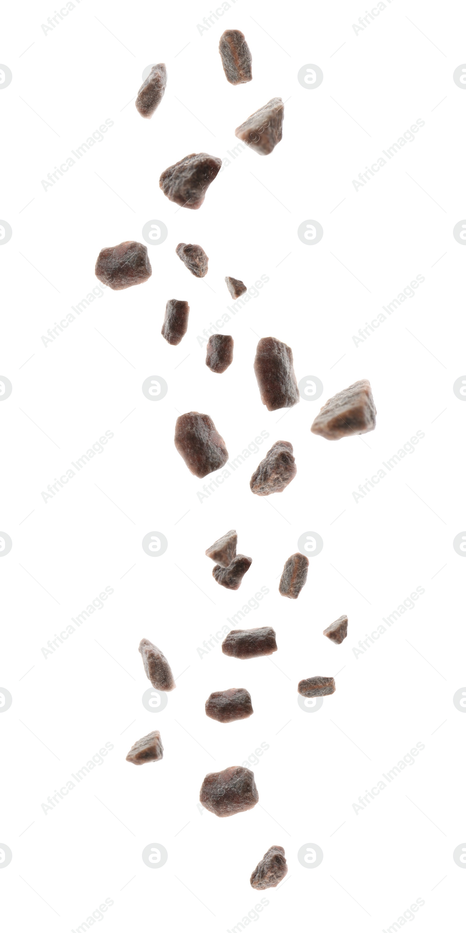 Image of Black salt crystals falling on white background