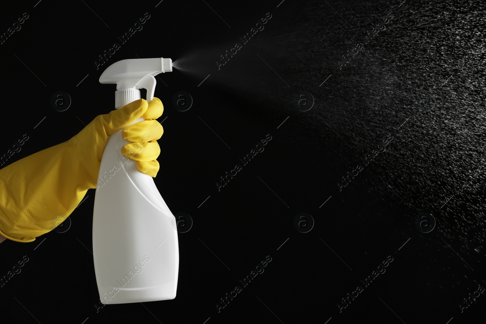 Photo of Person in gloves spraying detergent on black background, closeup. Space for text