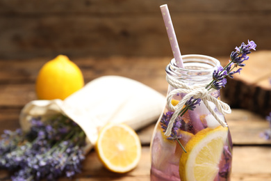 Photo of Fresh delicious lemonade with lavender in bottle, closeup. Space for text