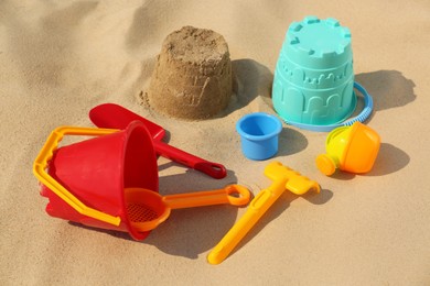 Photo of Set of plastic beach toys on sand. Outdoor play