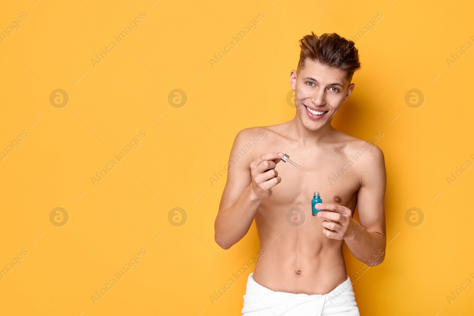 Photo of Handsome man with serum on orange background. Space for text