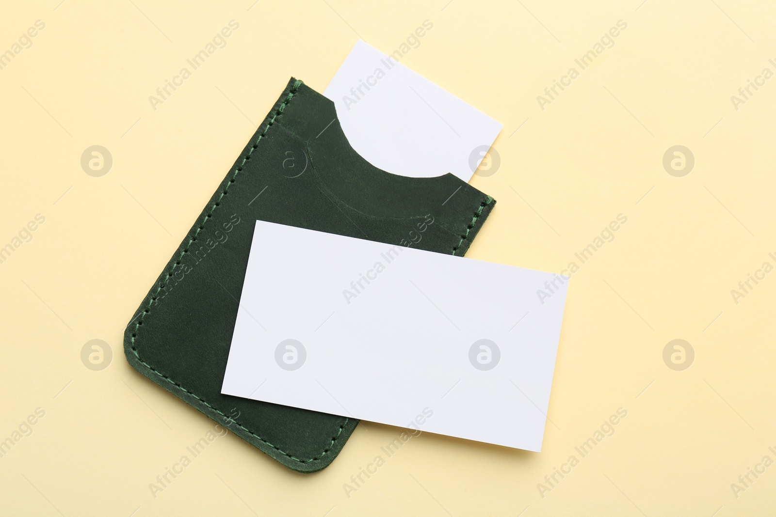 Photo of Leather business card holder with blank cards on beige background, top view