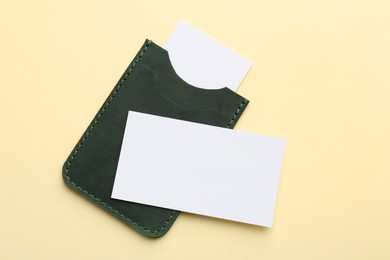 Photo of Leather business card holder with blank cards on beige background, top view