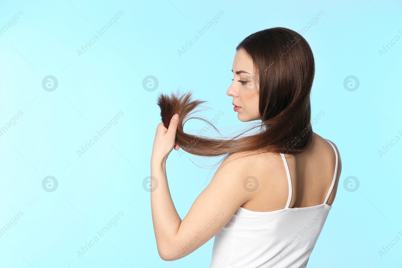 Photo of Woman with damaged hair and space for text on color background. Split ends