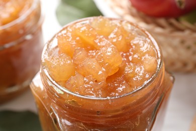 Photo of Glass jar of delicious apple jam on table, closeup