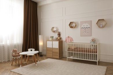 Photo of Modern baby room interior with stylish furniture and toys