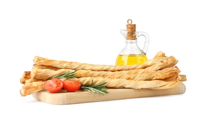 Wooden board with delicious grissini, oil, rosemary and tomato on white background