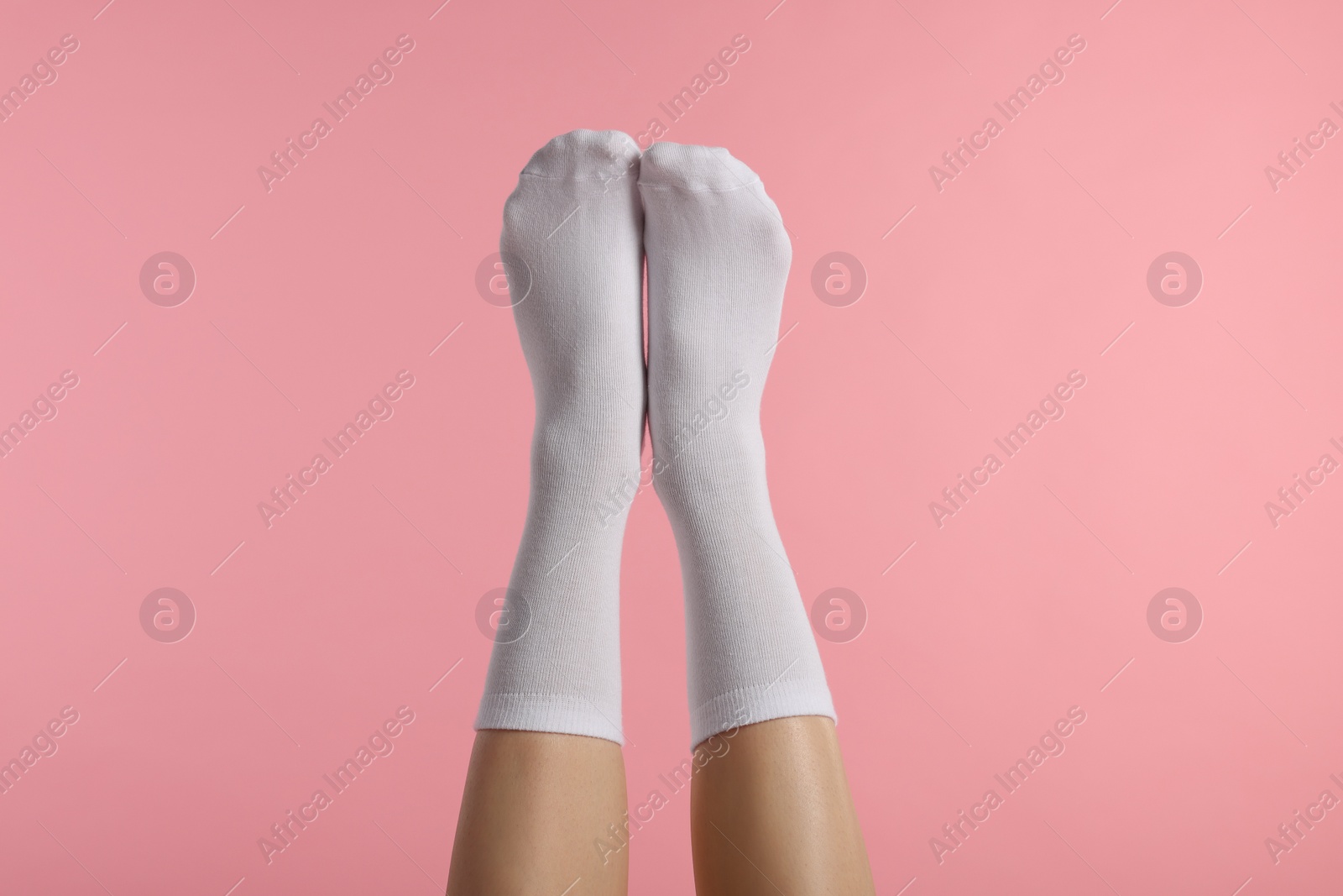 Photo of Woman in stylish white socks on pink background, closeup